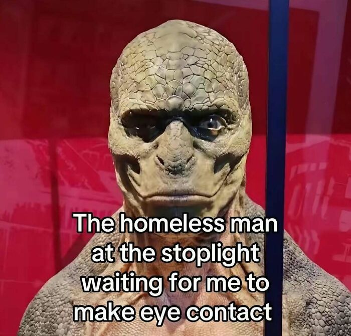 Close-up of a reptile-costumed figure with meme text about a homeless man at a stoplight from funny relatable memes.