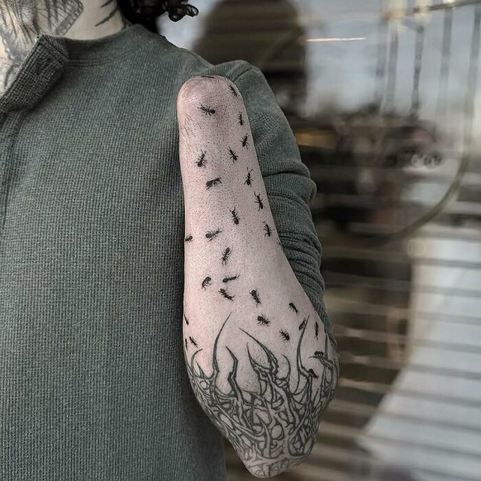 Brazo tatuado con hormigas negras realistas, un diseño original y llamativo entre tatuajes graciosos y terribles.