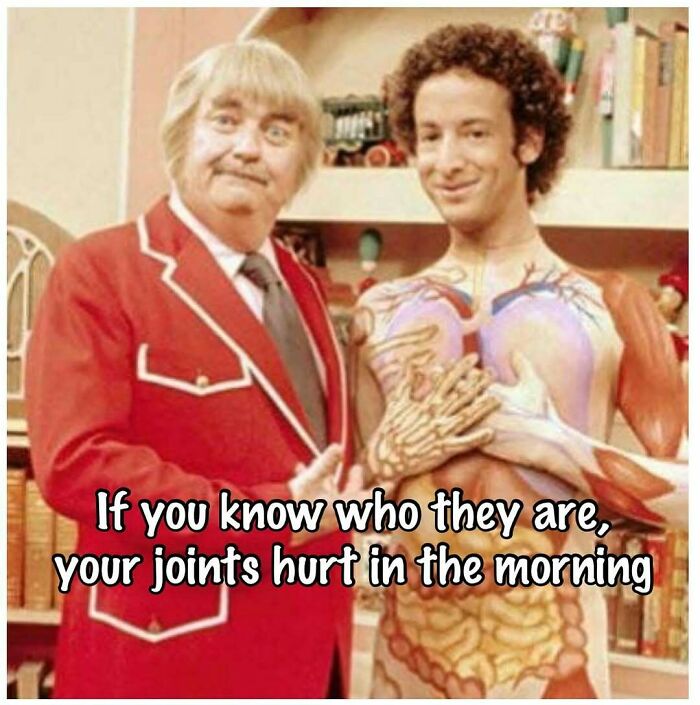 Two men, one in a red blazer and one with an anatomical torso, in a vintage 80s setting celebrating the good old 80s.