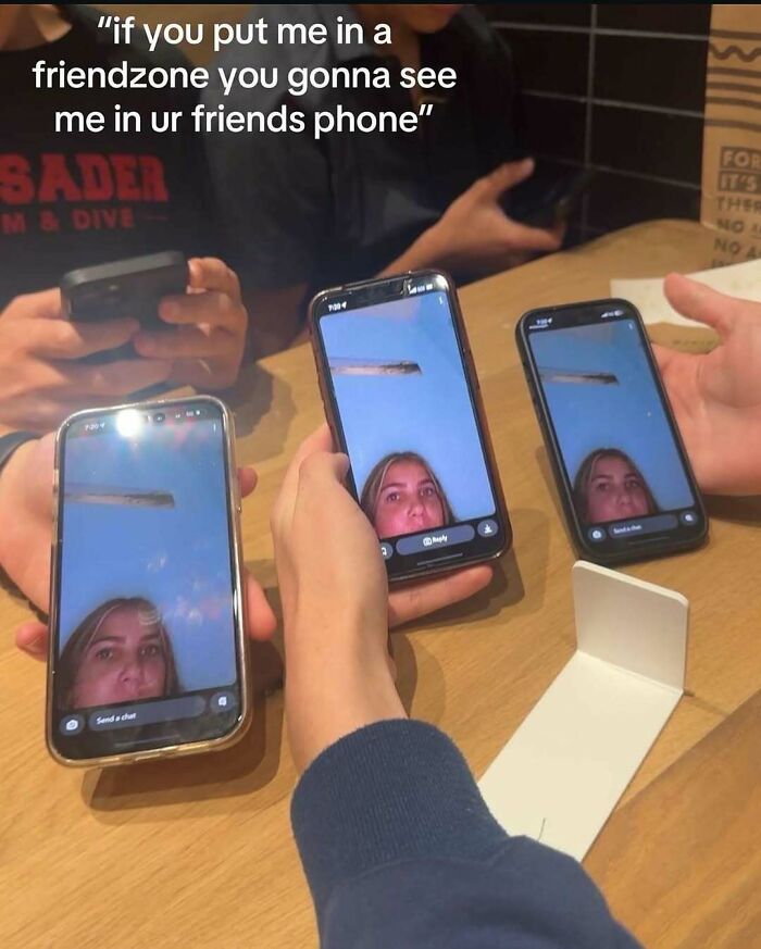 Group of people holding phones showing the same cringey selfie with text about friendzone on an Instagram account.