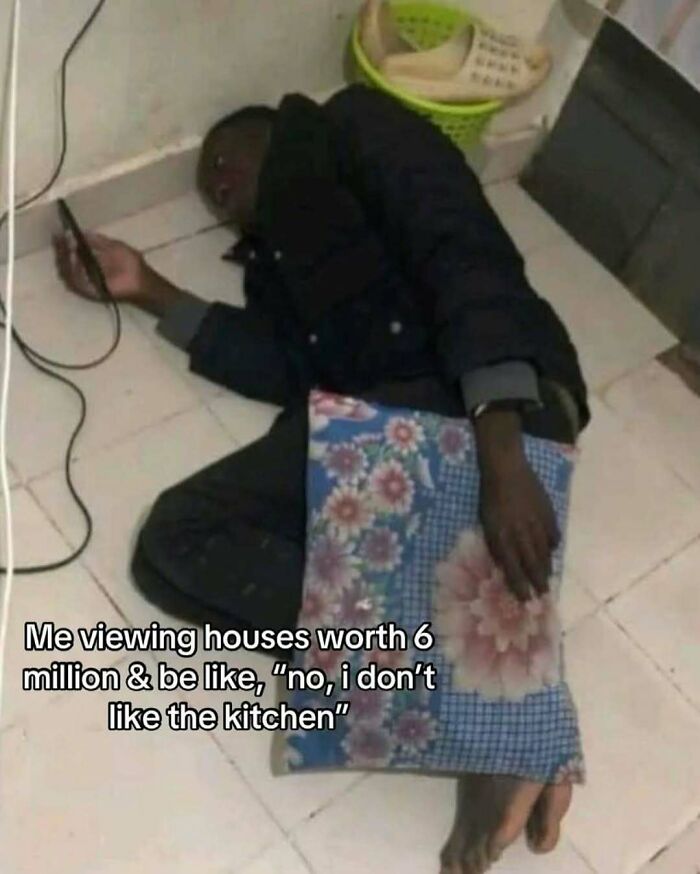 Person lying on the floor holding a phone with a pillow, relatable meme about viewing expensive houses shared on IG page.