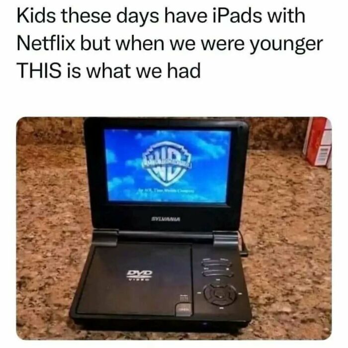 Portable DVD player on countertop showing Warner Bros logo, highlighting nostalgia for millennials growing up in the 80s, 90s, and 00s.