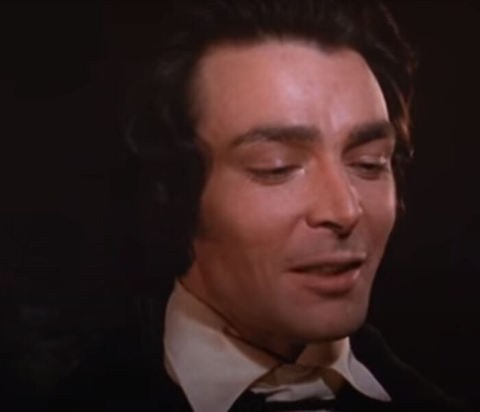 Close-up of a man with dark hair and vintage attire representing notable people who passed away in 2025.