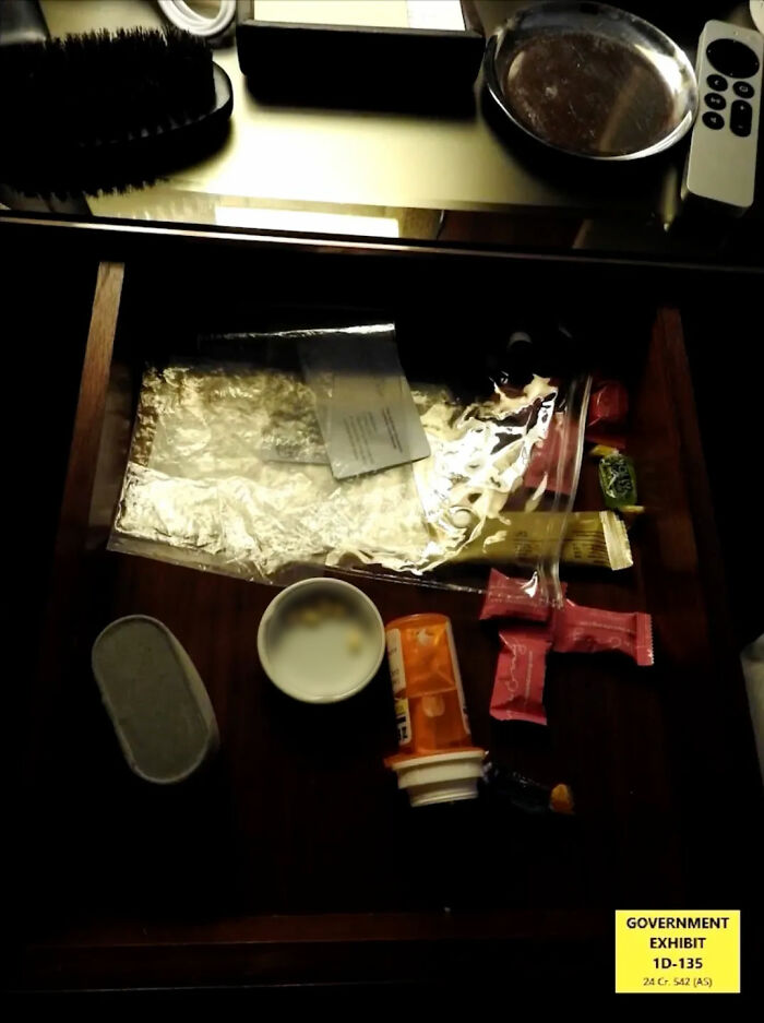 Open drawer with various items including pills, wrappers, and a brush, part of Diddy trial disturbing items evidence.