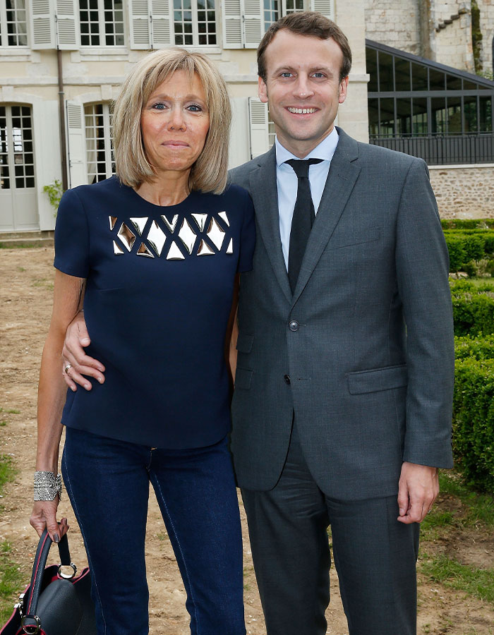 Emmanuel and Brigitte Macron posing outdoors, sparking rumors about grooming and teacher-student past. Emmanuel and Brigitte Macron posing outdoors, sparking rumors about grooming and teacher-student past.