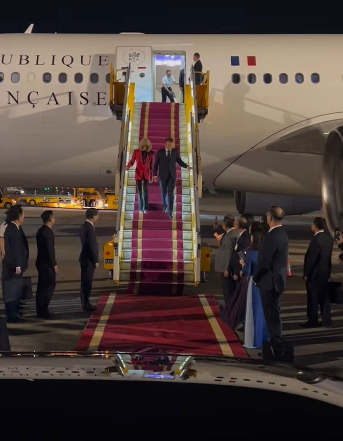 Emmanuel and Brigitte Macron descending airplane stairs at airport amid grooming rumors and teacher-student past discussion. Emmanuel and Brigitte Macron descending airplane stairs at airport amid grooming rumors and teacher-student past discussion.