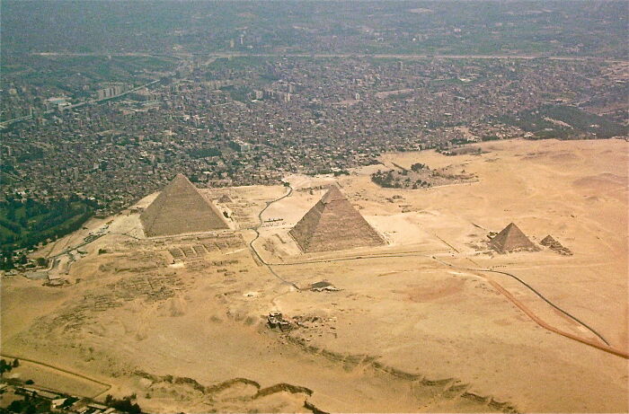 Aerial view of archaeological discoveries showing the pyramids near an urban area, highlighting ancient structures.