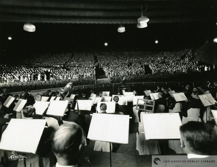 Orchestra performing in front of a massive crowd, offering an alternate angle of an iconic historical event.