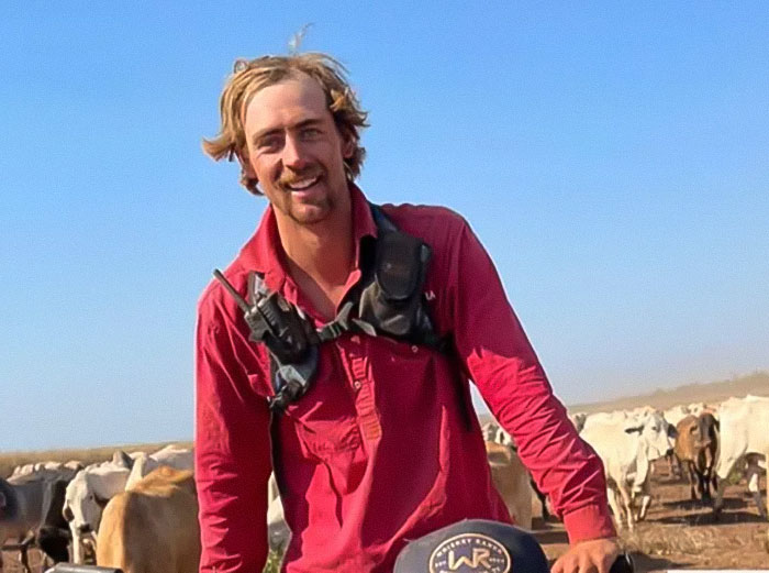 Man in pink shirt outdoors with cattle in background, illustrating the lesson learnt involving childhood friend incident.