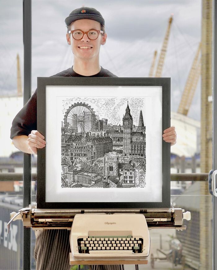 Young artist holding detailed typewriter drawing of London landmarks with original typewriter in foreground.