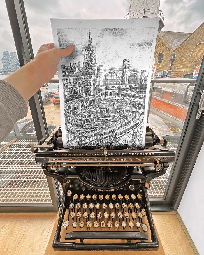 Hand holding a detailed typewriter drawing of a city scene created by a young artist using an Underwood typewriter.
