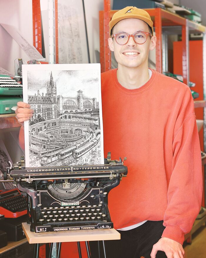 Young artist holding detailed typewriter drawing of a train station, showcasing impressive typewriter art skills.