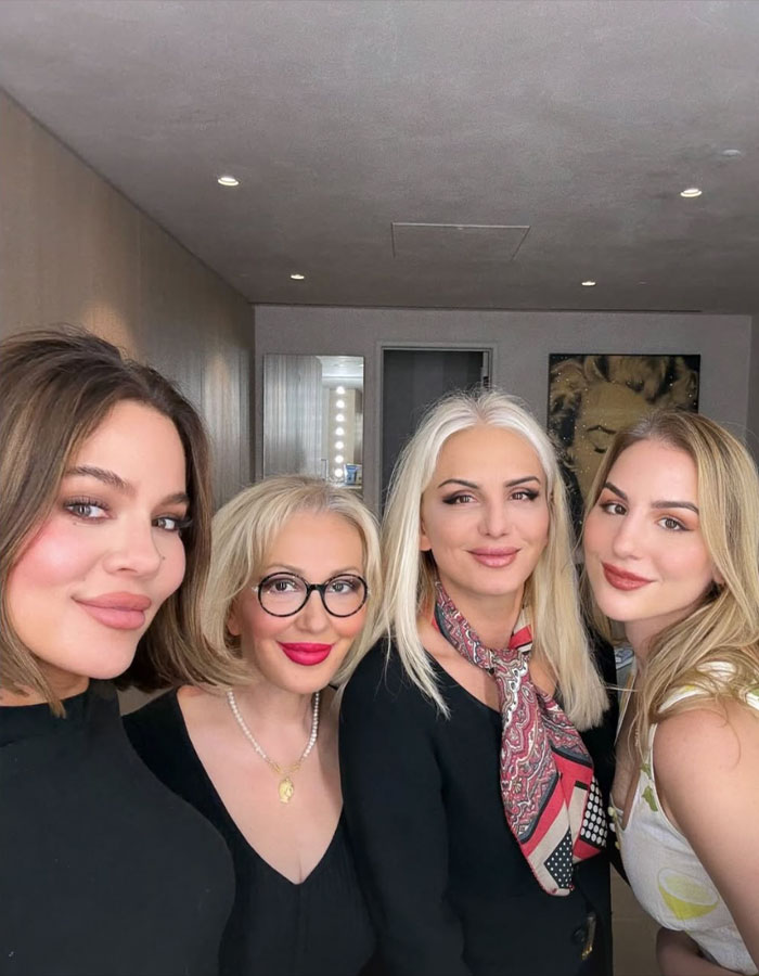 Khloe Kardashian with three women posing indoors, highlighting discussions about plastic surgery and stitched results. Khloe Kardashian with three women posing indoors, highlighting discussions about plastic surgery and stitched results.