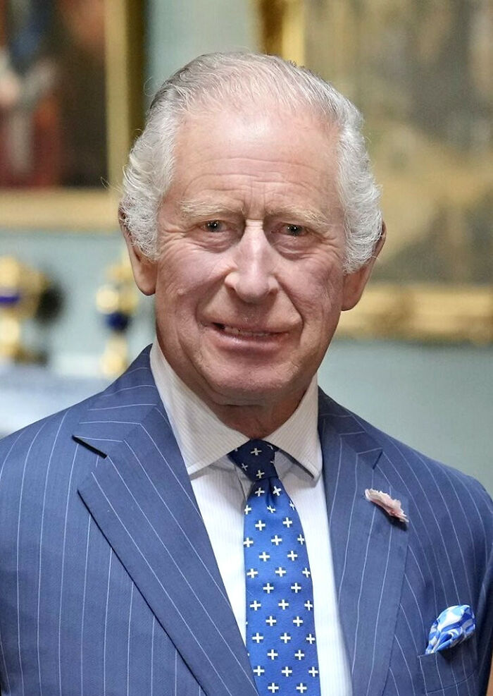 Portrait of an elderly royal figure wearing a blue pinstripe suit, highlighting surprising facts about royals history.