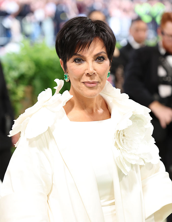 Kris Jenner posing at a public event wearing a white outfit and emerald earrings after plastic surgery makeover. Kris Jenner posing at a public event wearing a white outfit and emerald earrings after plastic surgery makeover.