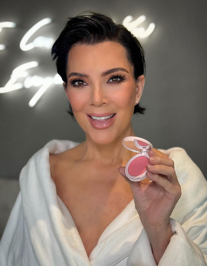 Woman with short dark hair holding a compact blush, highlighting Kris Jenner's plastic surgeon and viral new look transformation. Woman with short dark hair holding a compact blush, highlighting Kris Jenner's plastic surgeon and viral new look transformation.