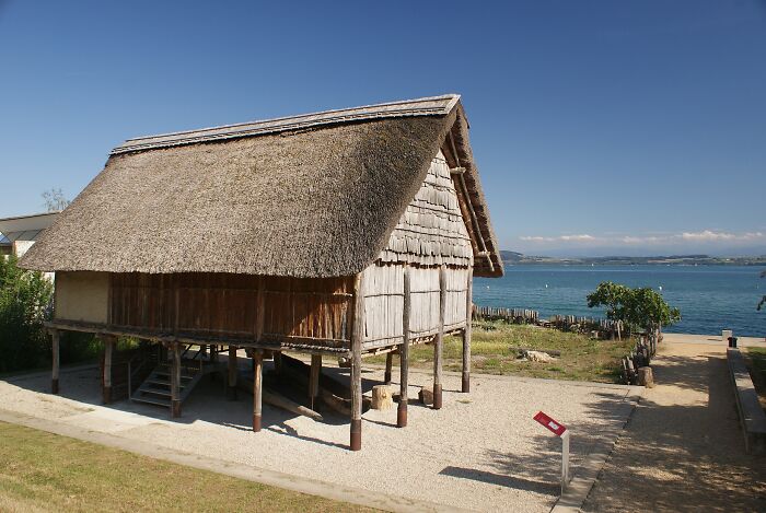 Thatched traditional structure on stilts by water showcasing hidden UNESCO gems in a serene natural setting.