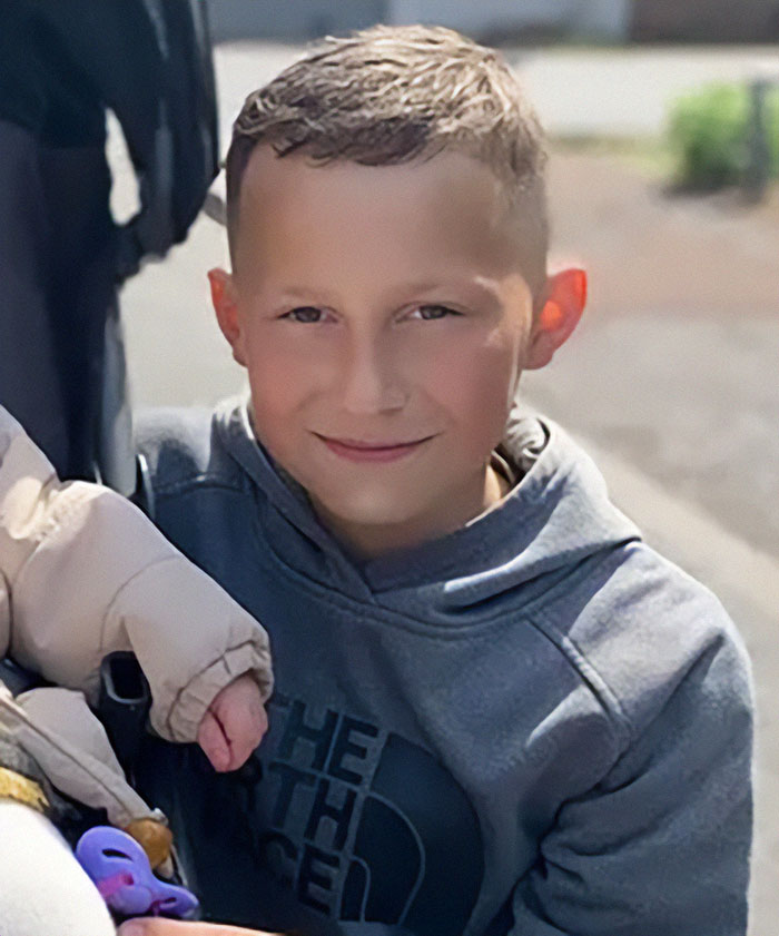 Young boy in a gray hoodie, related to news about children arrested after missing boy's body found in industrial park fire. Young boy in a gray hoodie, related to news about children arrested after missing boy's body found in industrial park fire.