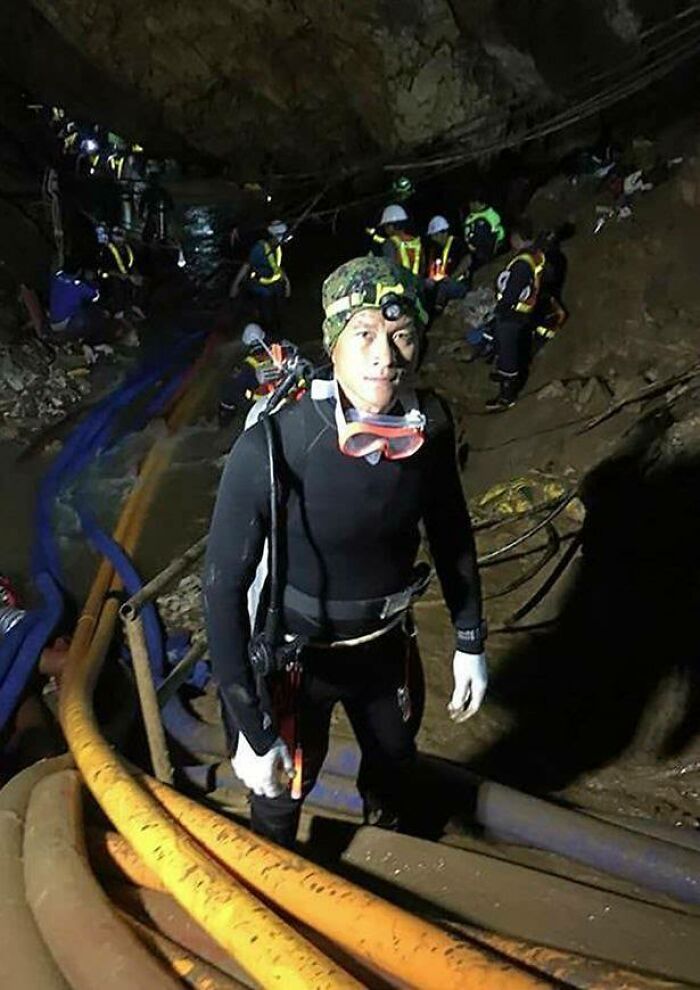 Rescuer in diving gear inside a cave with a team, part of unusual and wonderful real-life events rescue effort.