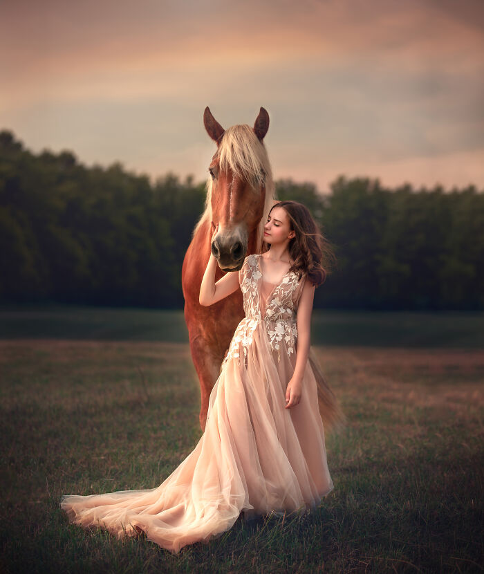 Young girl in a flowing gown gently embracing a horse, capturing the magical bond between children and animals in a whimsical portrait.