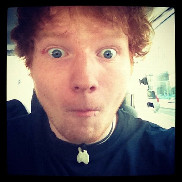 Close-up selfie of a surprised young man with blue eyes and curly hair in a casual setting, Instagram posts celebrity memory.