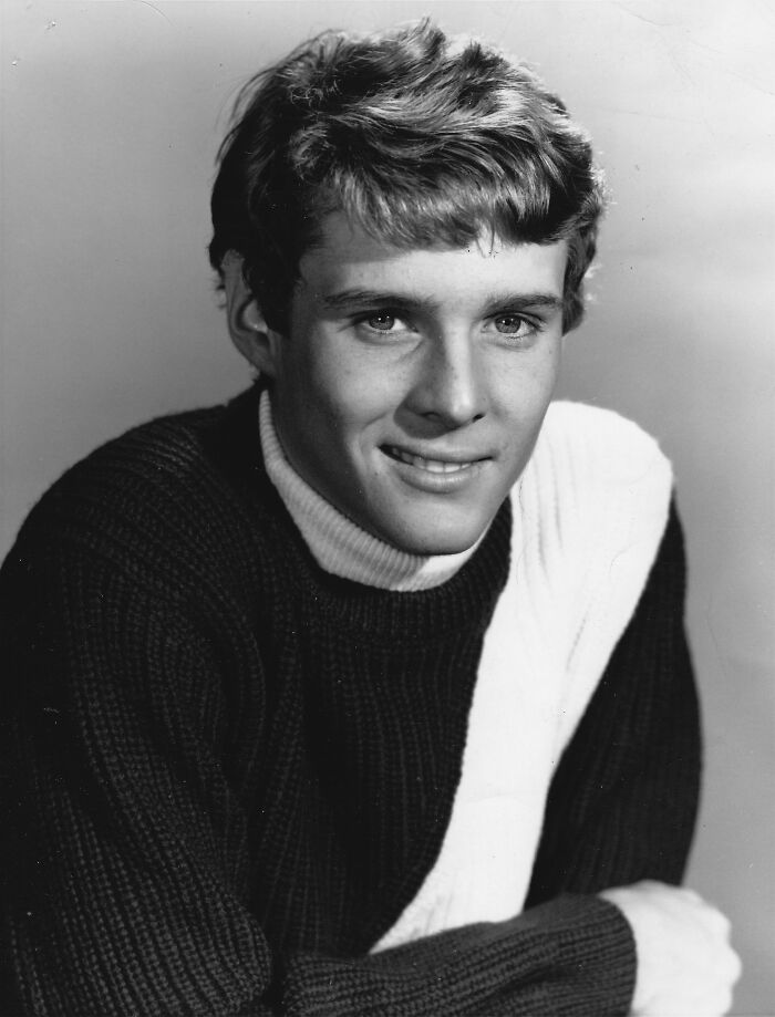 Young man in a black and white sweater smiling softly, representing notable people who passed away in 2025.
