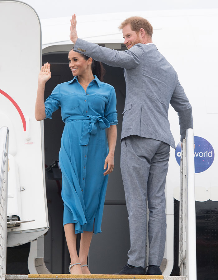 Meghan Markle and Prince Harry waving while boarding an airplane, related to Meghan Markle's note to flight attendant viral story.