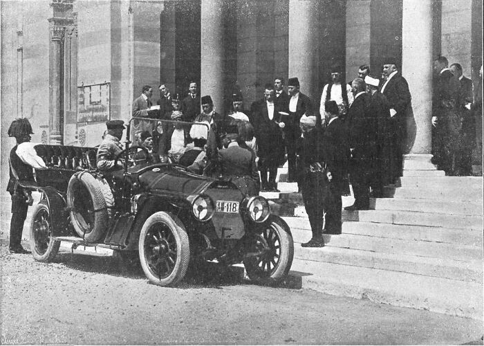 Historic black and white photo of a vintage car and group of men near columns depicting biggest mistakes that changed history.