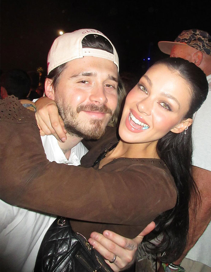 Bella Thorne smiling and hugging a man outdoors at night, related to Brooklyn Beckham wife Nicola Peltz warning story.