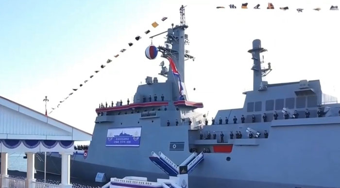 North Korean 5,000-ton warship docked with crew standing on deck during a military ceremony. North Korean 5,000-ton warship docked with crew standing on deck during a military ceremony.