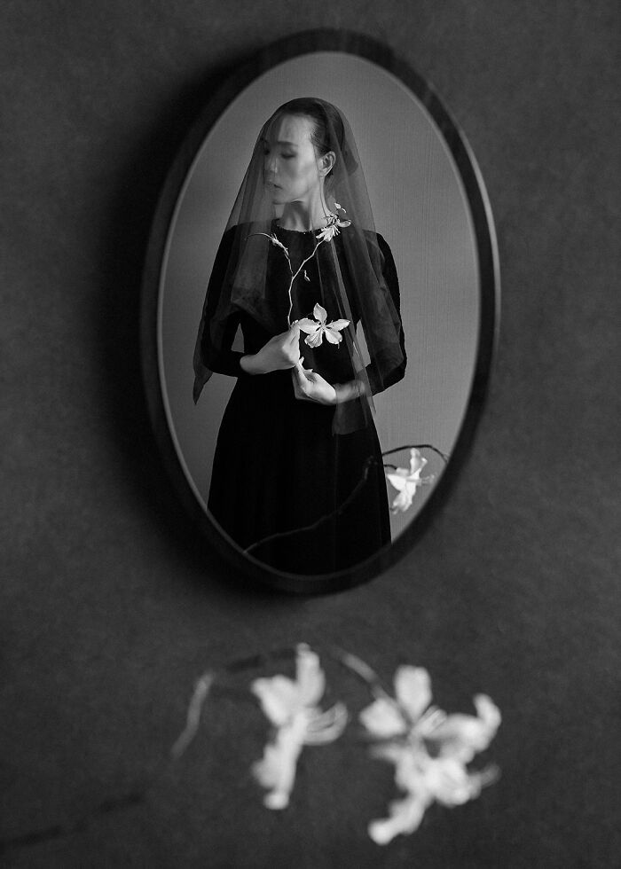 Black and white portrait of a veiled woman holding flowers, reflecting the power of a single frame in photography.