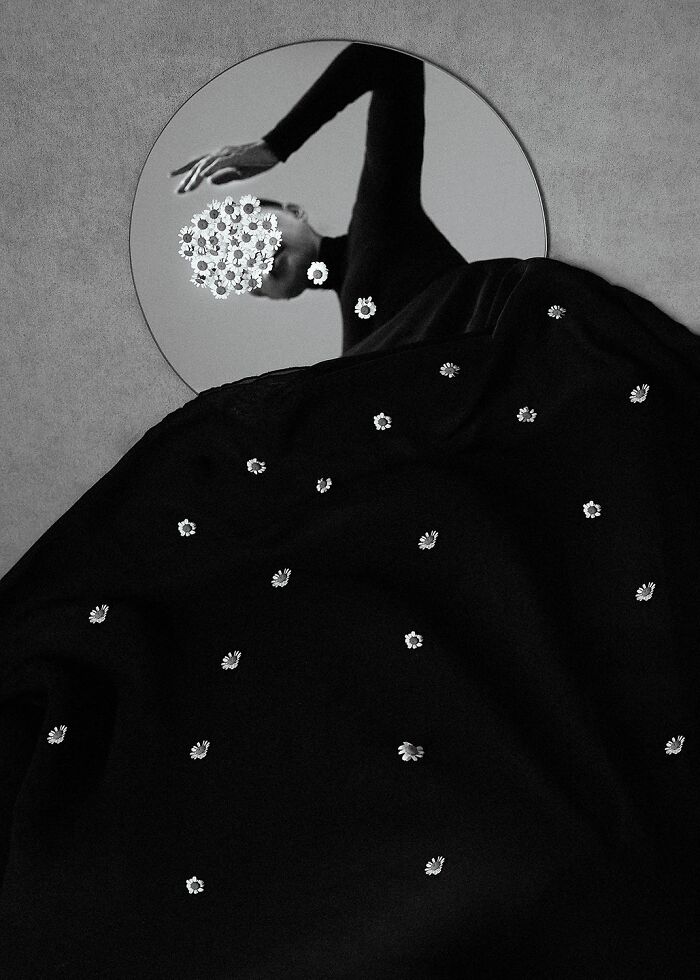 Abstract black and white photo featuring a figure reflected in a mirror with floral elements, showcasing power of a single frame.