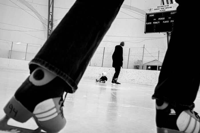 Black and white photo of ice skaters at a rink, capturing the power of a single frame in a 2025 photo contest winner.