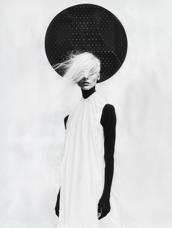 Black and white artistic portrait of a woman with white hair against a dotted circular backdrop, 2025 one shot photo contest winner.