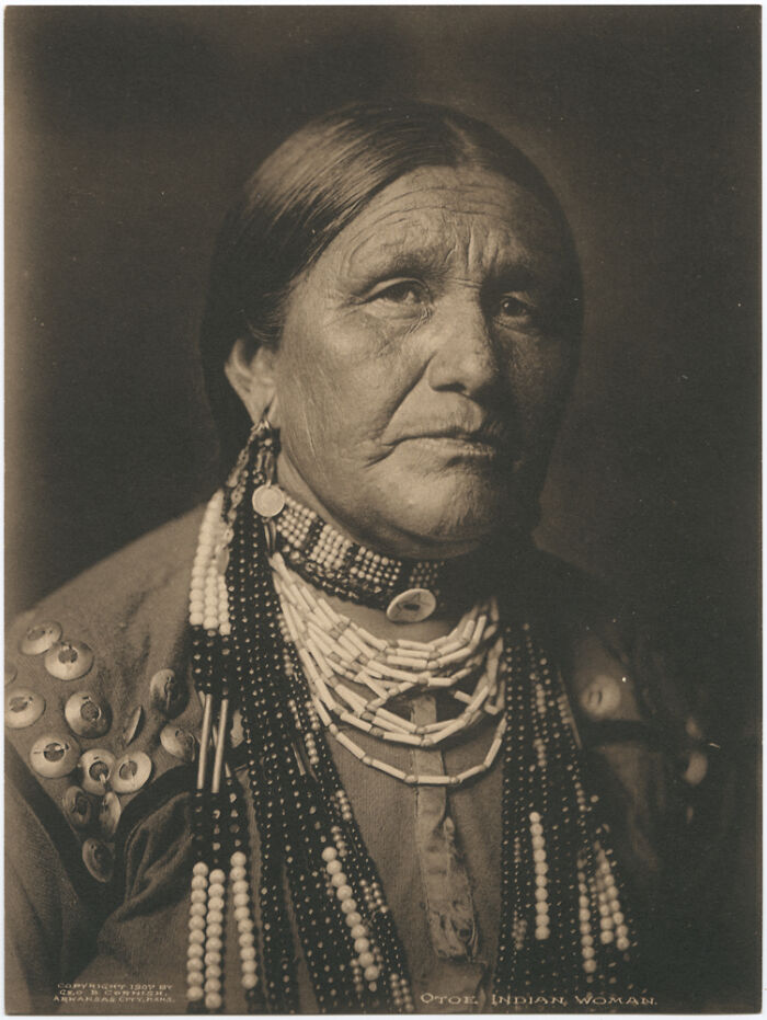 Native American female strength shown in a time-weathered photograph of a woman wearing traditional beaded jewelry.