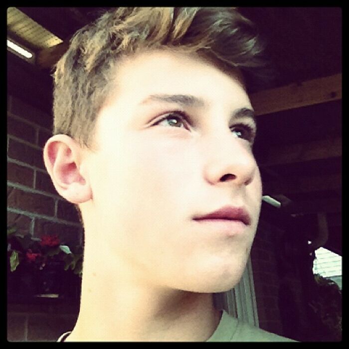 Young male celebrity in a nostalgic Instagram post, looking thoughtfully into the distance with soft natural lighting.