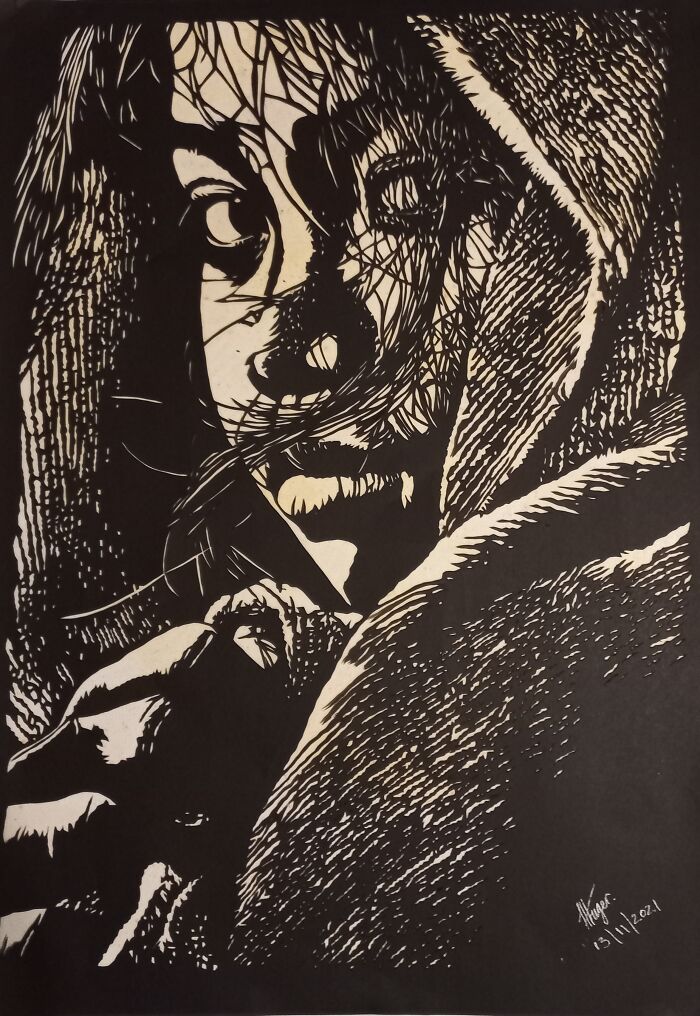 Black and white intricate paper art showing a detailed portrait of a person with expressive eyes and textured shadows.