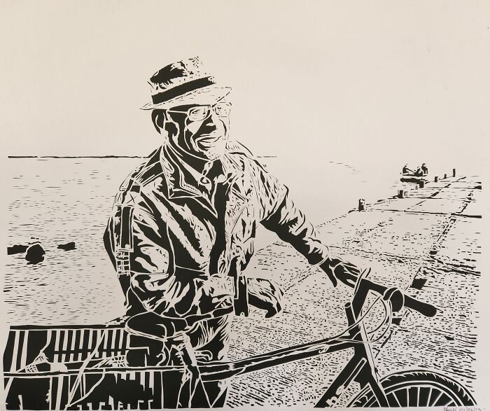 Black and white intricate paper art of an elderly man smiling, holding a bicycle near a waterfront in detailed paper art style.