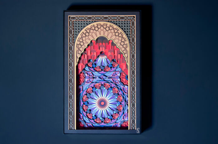 Intricate and colorful paper art piece featuring a detailed geometric pattern in vibrant shades of red and blue.