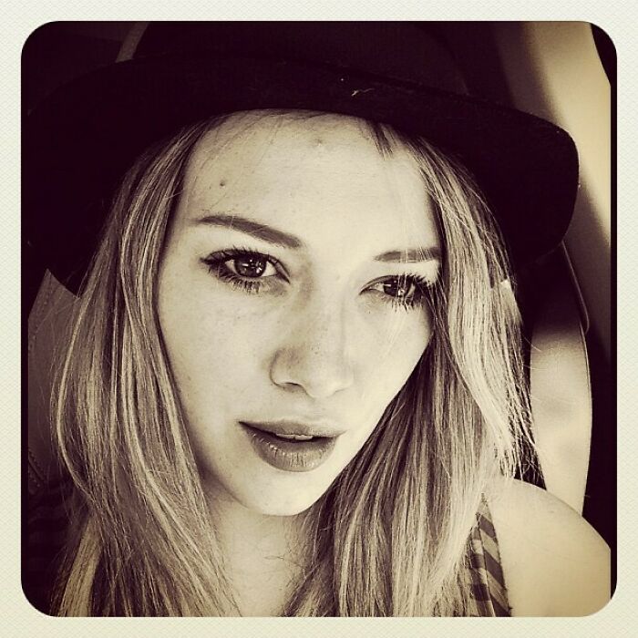 Close-up of a young woman in a black hat, reflecting the vintage style of Instagram posts celebrities shared way back.