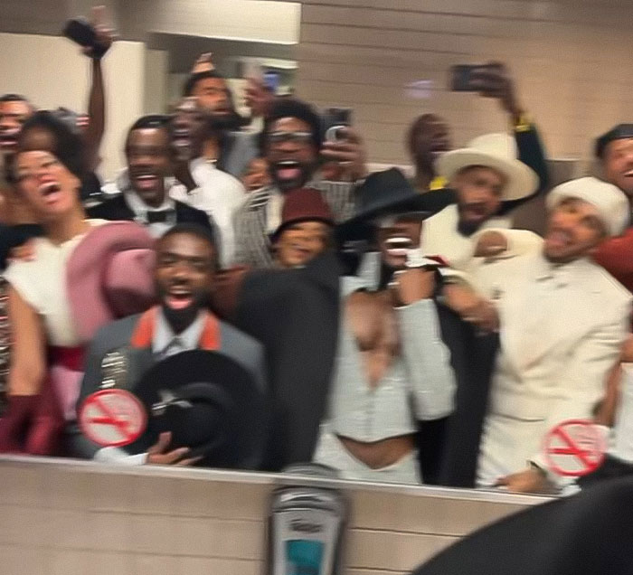 Group of celebs capturing moments on phones inside event, breaking Met Gala no phones rule to reveal behind-the-scenes glimpse.