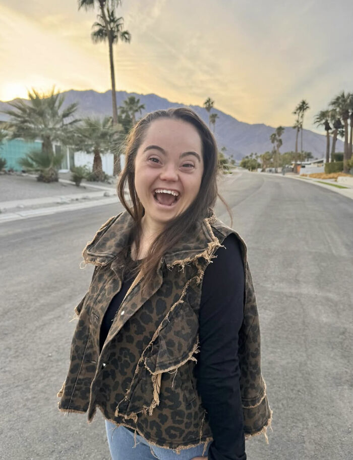 Young woman with Down syndrome smiling on a street at sunset amid backlash against social media trend exploiting Down syndrome adult content. Young woman with Down syndrome smiling on a street at sunset amid backlash against social media trend exploiting Down syndrome adult content.