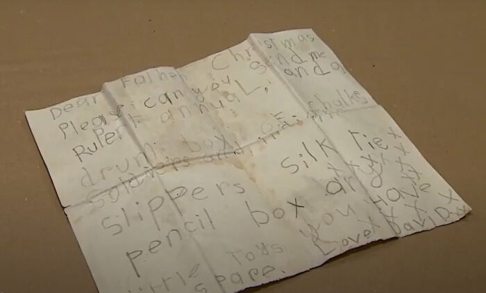 Handwritten Christmas letter on aged paper, a bizarre historical artifact showing old child’s wish list and handwriting.