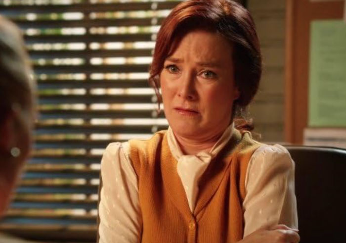 Actress from Desperate Housewives and Young Sheldon looking emotional in a scene wearing a brown vest and cream blouse.