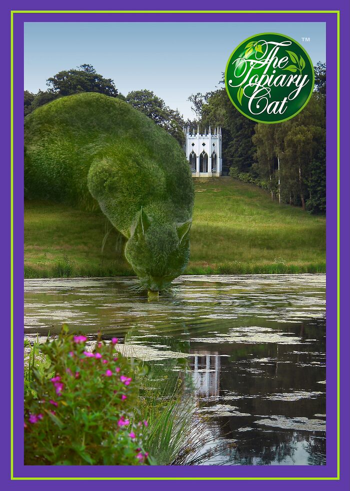 Green topiary cat shaped like a bush drinking from a pond in a scenic outdoor park setting.