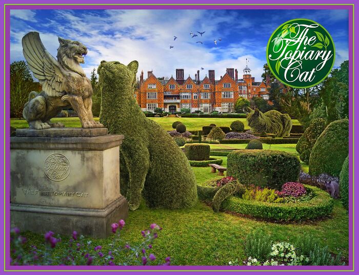 Topiary cat shaped bush next to a winged stone statue in a colorful garden with a large historic mansion in the background.