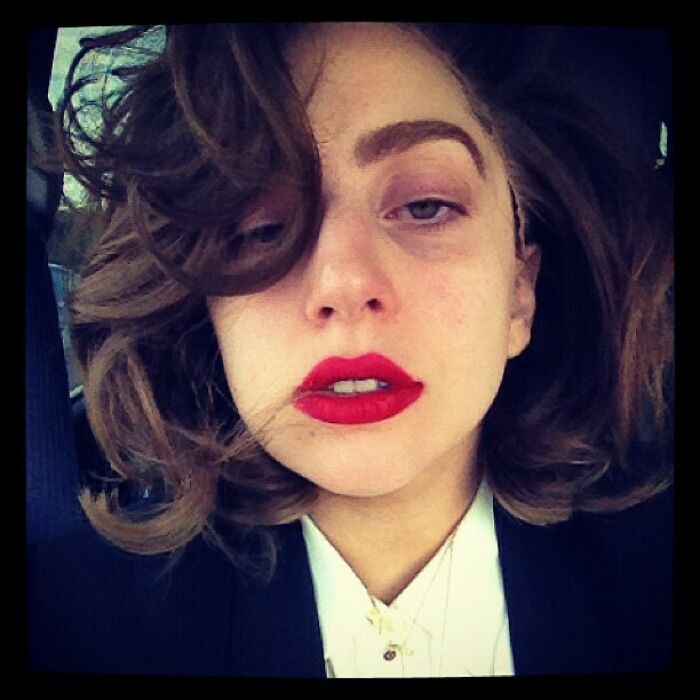 Young woman with wavy hair and bold red lipstick, styled in a vintage look, from early celebrity Instagram posts.