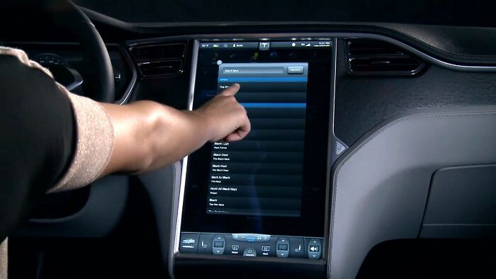 Person using touchscreen infotainment system inside car, illustrating smart tech and boomer opinions on technology use.