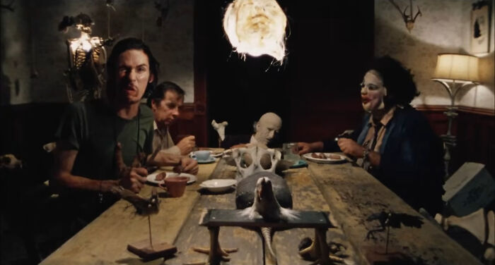 Actors sitting around a creepy dinner table scene showcasing horrifying behind-the-scenes facts from movies and TV productions.