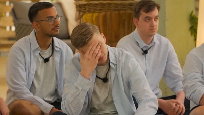 Three young men sitting indoors wearing light shirts and microphones, participating in a Virgin Island singles challenge show. Three young men sitting indoors wearing light shirts and microphones, participating in a Virgin Island singles challenge show.